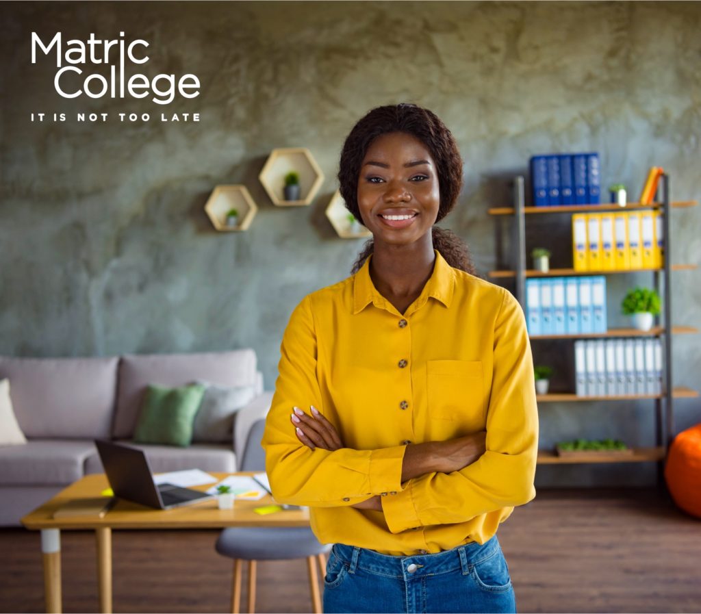 A confident woman standing in a modern home office with a laptop and documents behind her. Managing your own business starts with the right skills and mindset—this image reflects readiness and independence.