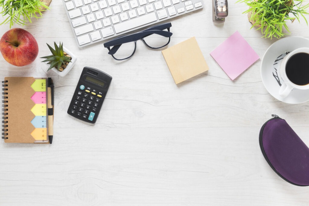 Organised home office desk setup with calculator, notebook, and coffee—perfect for learning the difference between bookkeeping and accounting.