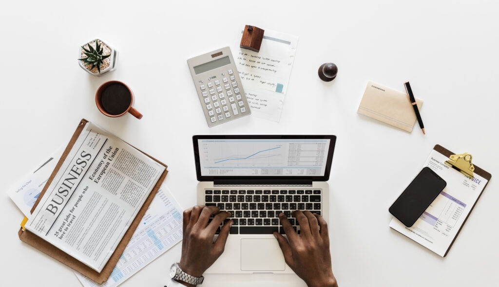 Business tools, finance reports, and hands on a laptop—ideal for choosing the right certified bookkeeping institute online.