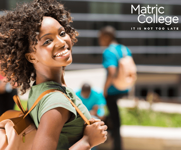 A young woman with a backpack smiles confidently on campus, representing the question: Can I Register For The Adult Matric If I Am 19 Years Of Age?