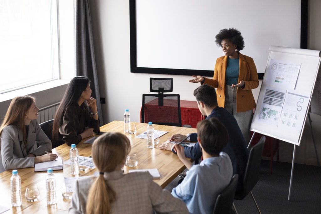 Professional woman presenting to a team in a boardroom, illustrating Optimising Corporate Training ROI: Strategies And Key Metrics in action.