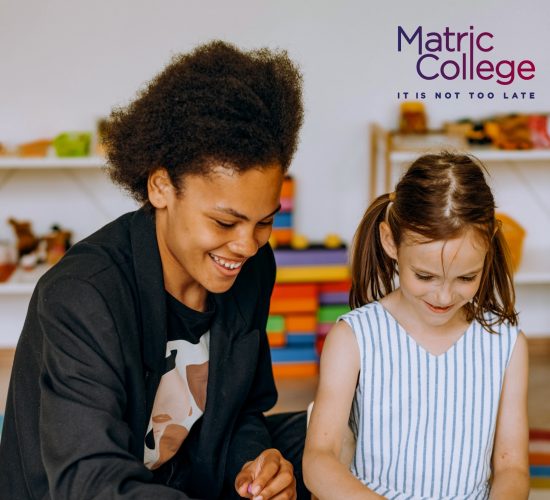 Caregiver smiling and interacting with a young child in a playroom, visually answering the question: What Do You Study In Day Care?